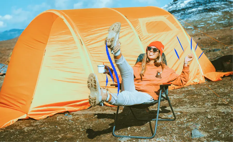 A woman sitting in front of a tent.