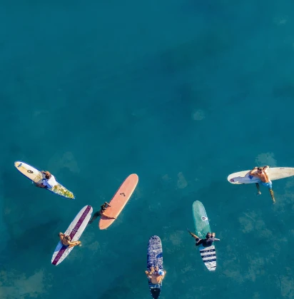 People sitting on surfboards in the water